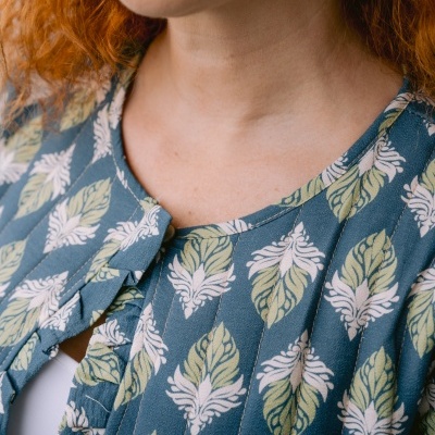 Blusa azul com padrão de folhas verdes e brancas e folho