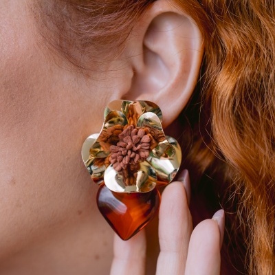 Brinco pendente em forma de flor dourada com coração castanho