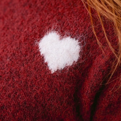 Pulôver vermelho com coração branco bordado e cabelo ruivo