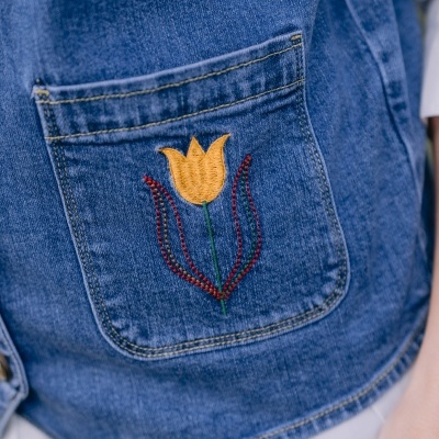 Bolso de ganga azul com bordado de flor amarela e folhas vermelhas e verdes