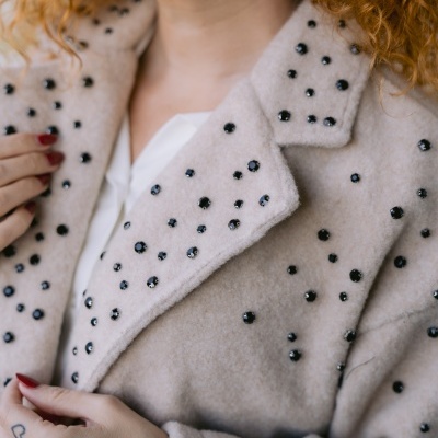 Casaco bege felpudo com cristais pretos aplicados em padrão disperso