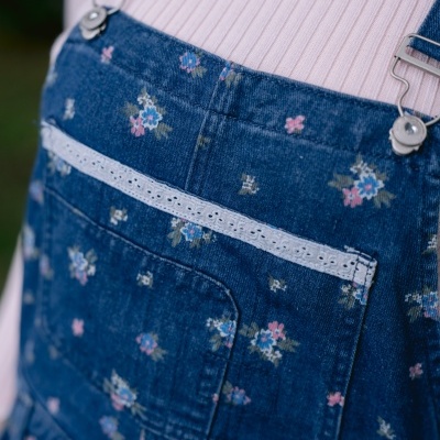 Salopete denim azul com flores e renda, usada com camisola rosa
