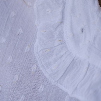 tecido branco com pontos texturados e babado