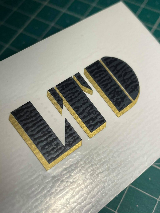 LTD Logo em Vinil Cartão branco com relevo e texto LID em preto e dourado