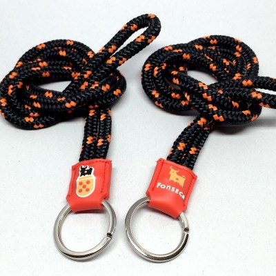 Porta-chaves de corda preta com padrão laranja e acabamento silicone vermelho com imagens distintas.