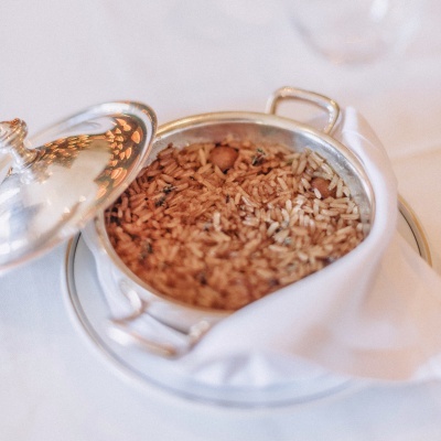 Panela prateada com arroz cozido e tampa parcialmente aberta