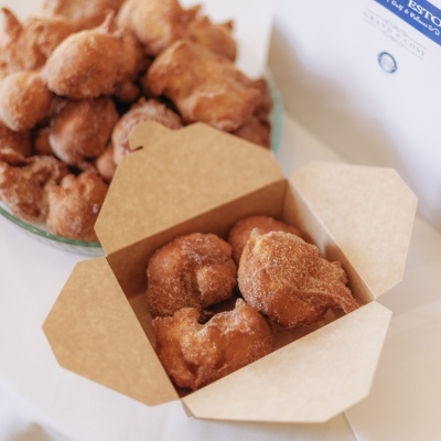 Sonhos de canela dentro de caixa de cartão e num prato de vidro