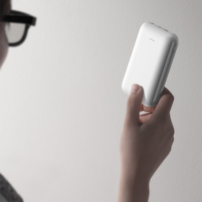 Dispositivo eletrónico branco com LEDs indicativos na mão de uma pessoa