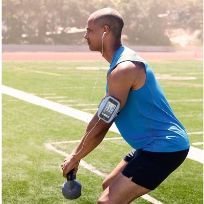 Homem a fazer exercício com kettlebell num campo de relva sintética