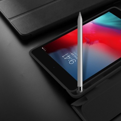 Tablet com caneta prateada sobre capa preta num fundo escuro