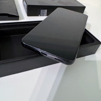 Smartphone preto dentro de caixa preta sobre superfície branca