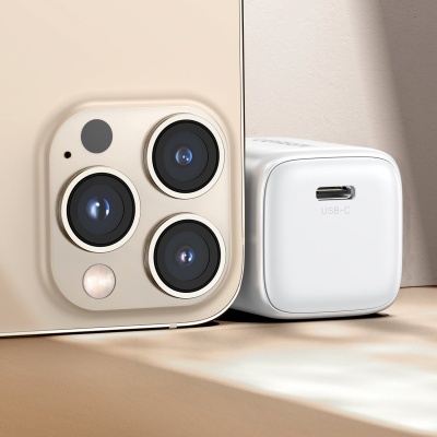 Smartphone dourado com três câmaras ao lado de carregador branco USB-C