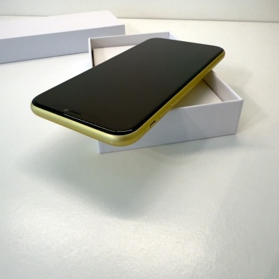 Smartphone dourado com ecrã preto numa caixa branca aberta