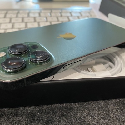 Smartphone Apple iPhone verde com três câmaras na caixa preta aberta