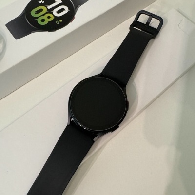 Relógio inteligente preto com caixa branca ao lado