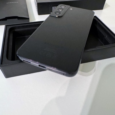 Smartphone preto com duas câmaras traseiras e caixas pretas ao fundo