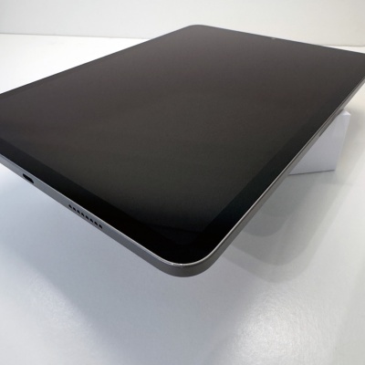 Tablet moderno com ecrã preto e bordas metálicas prateadas sobre superfície branca