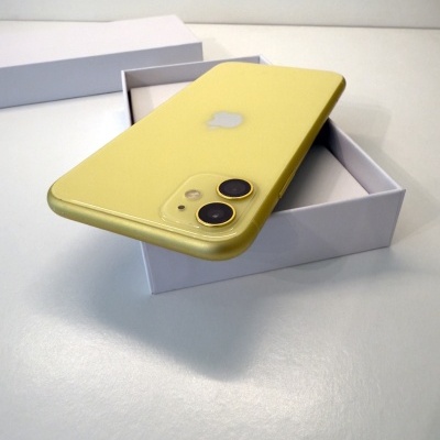 Smartphone amarelo com duas câmeras traseiras em caixa branca aberta