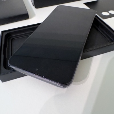 Smartphone preto sobre embalagem preta aberta em superfície branca