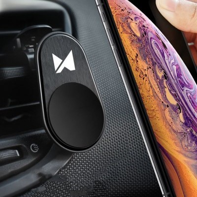 Suporte magnético preto para telemóvel num carro com smartphone próximo