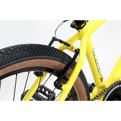 Detalhe traseiro de bicicleta amarela com travão V-brake preto e pneu negro com borda castanha