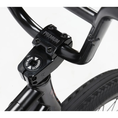 Guiador preto de bicicleta com peças de metal e pneus pretos