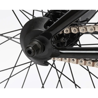 close-up da roda traseira de uma bicicleta com corrente e porca preta