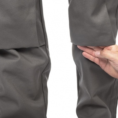 Calças cinzentas flexíveis com bainha esticada por uma mão