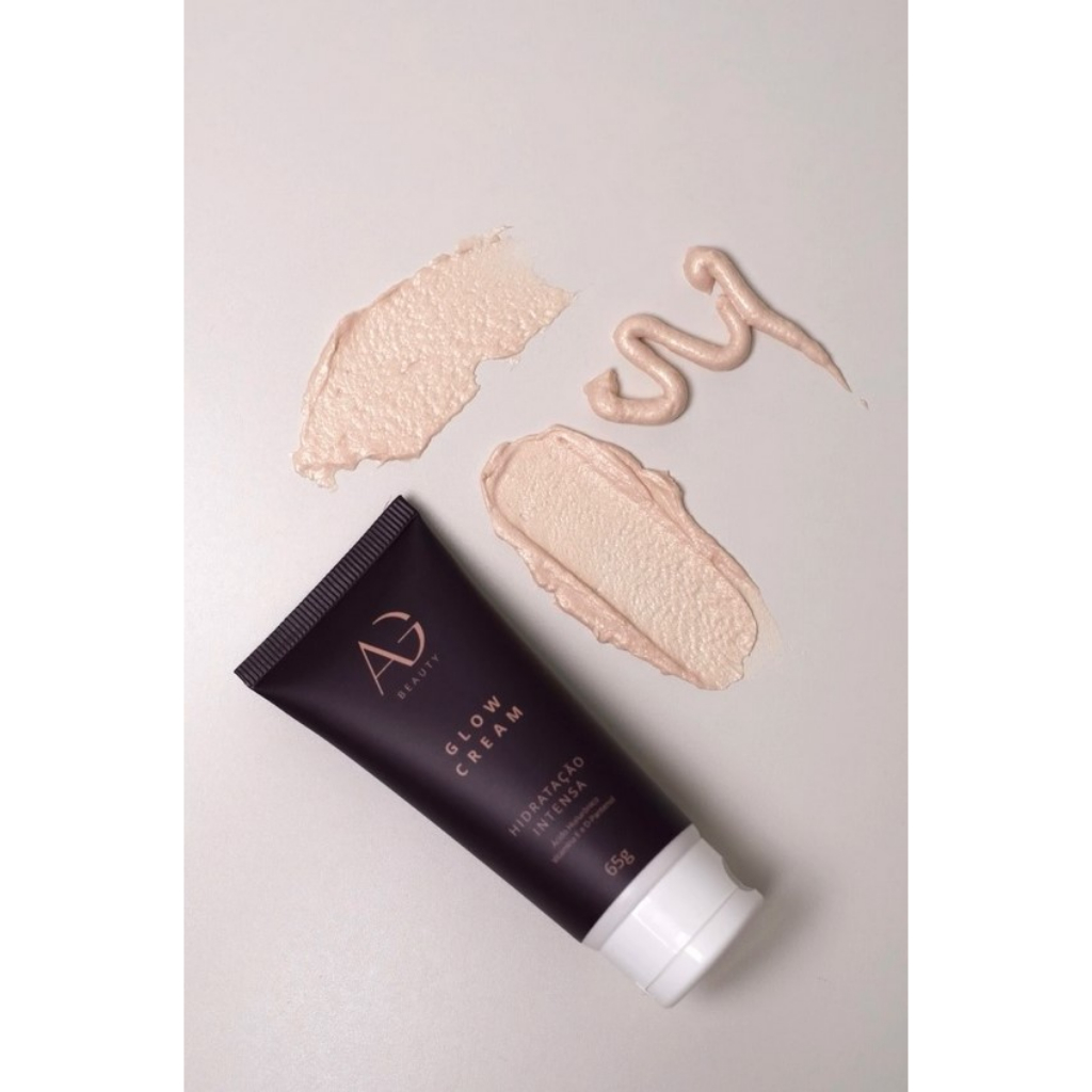 Glow Cream Hidratação Intensa Alyce Gontijo Tubo de creme hidratante preto com texto dourado e amostras de creme bege claro