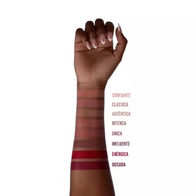 Braço com amostras de maquilhagem em tons variados e nomes ao lado