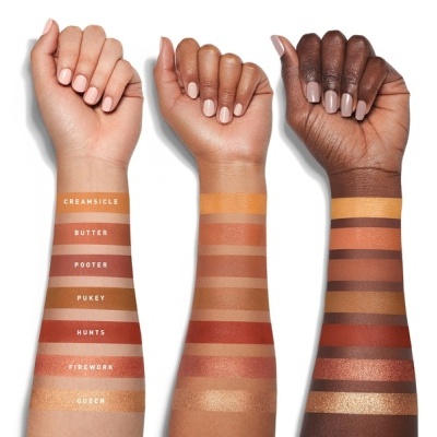 Três braços com faixas de maquilhagem em diferentes tons, contendo nomes das cores em texto junto a cada faixa