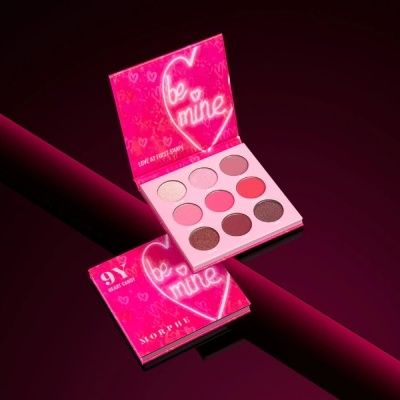 Paleta de sombras de olhos Morphe be mine rosa e vermelha aberta e fechada sobre superfície vermelha
