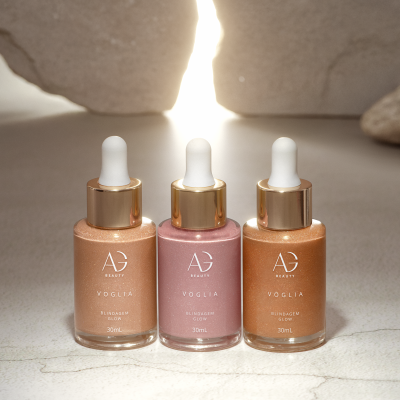 Três frascos de vidro com conta-gotas coloridos em fundo iluminado