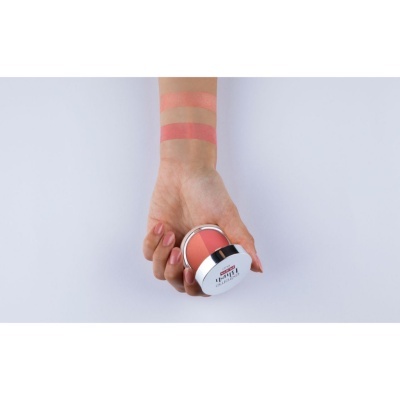 Pote de cosmético cor de pêssego com amostras em antebraço