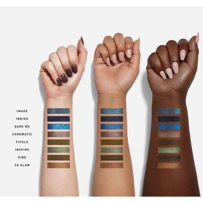 Três braços com diferentes tons de pele mostram amostras de sombras coloridas brilhantes alinhadas em faixas