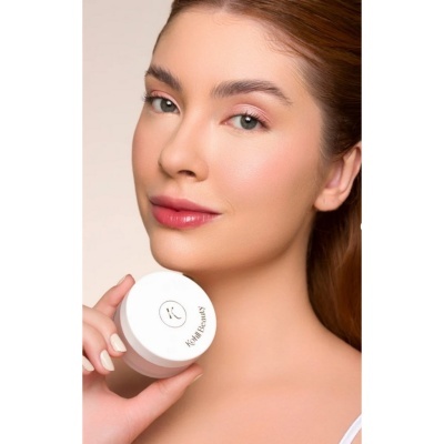 Mulher segurando frasco branco de produto Kiehl's BEAUTY