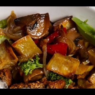 Prato branco com vegetais cozidos, pão integral e molho branco