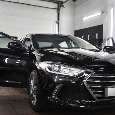 Carro preto com portas abertas em garagem interior