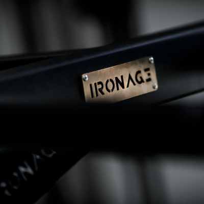 Placa metálica dourada com o texto 'IRONAGE' numa estrutura preta