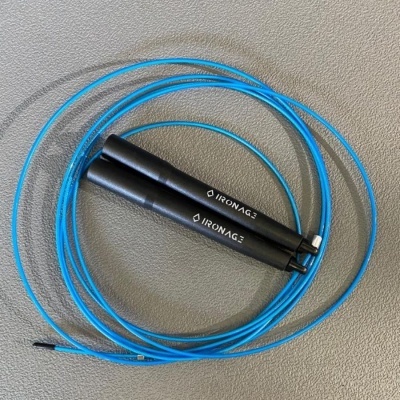 Corda de saltar azul com pegas pretas e texto IRONAGE sobre superfície cinza