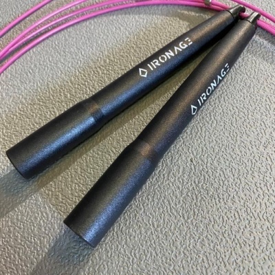 Corda de saltar com cabos pretos e corda rosa sobre superfície cinzenta