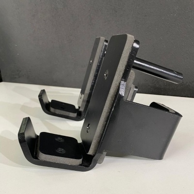 Suporte metálico preto fosco para instrumentos com parafusos sobre superfície branca