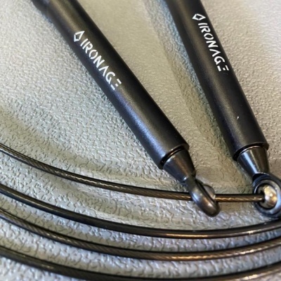 Equipamento de exercício com pegas pretas e fios metálicos com texto WHITE IRONAGE