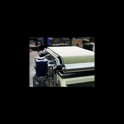 Tapete verde claro numa estrutura metálica com motor azul num ambiente industrial