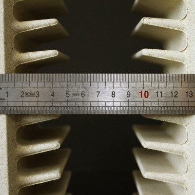 Régua metálica sobre peça mecânica bege com ranhuras largas