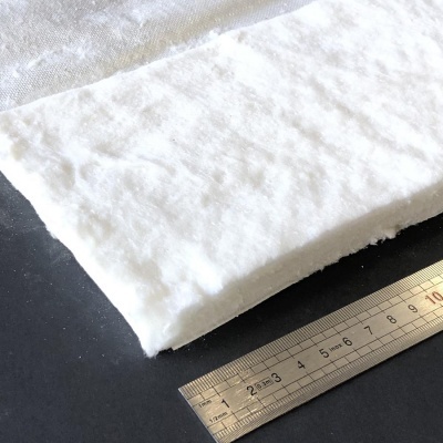 Painel rectangular branco com textura fibrosa e régua metálica ao lado para medida