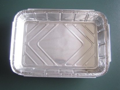 Tabuleiro rectangular descartável de alumínio sobre fundo verde-escuro