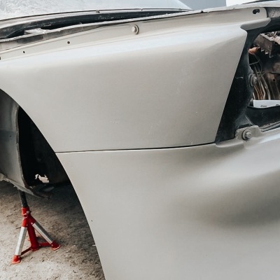 Parte frontal de carro cinzento em suporte vermelho sem rodas