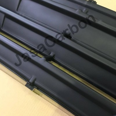 Grelha frontal preta de carro com linhas horizontais sobre superfície amarela