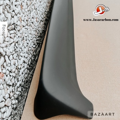 Spoiler automóvel preto junto a parede de seixos brancos com logótipo e URL Jasacarbon